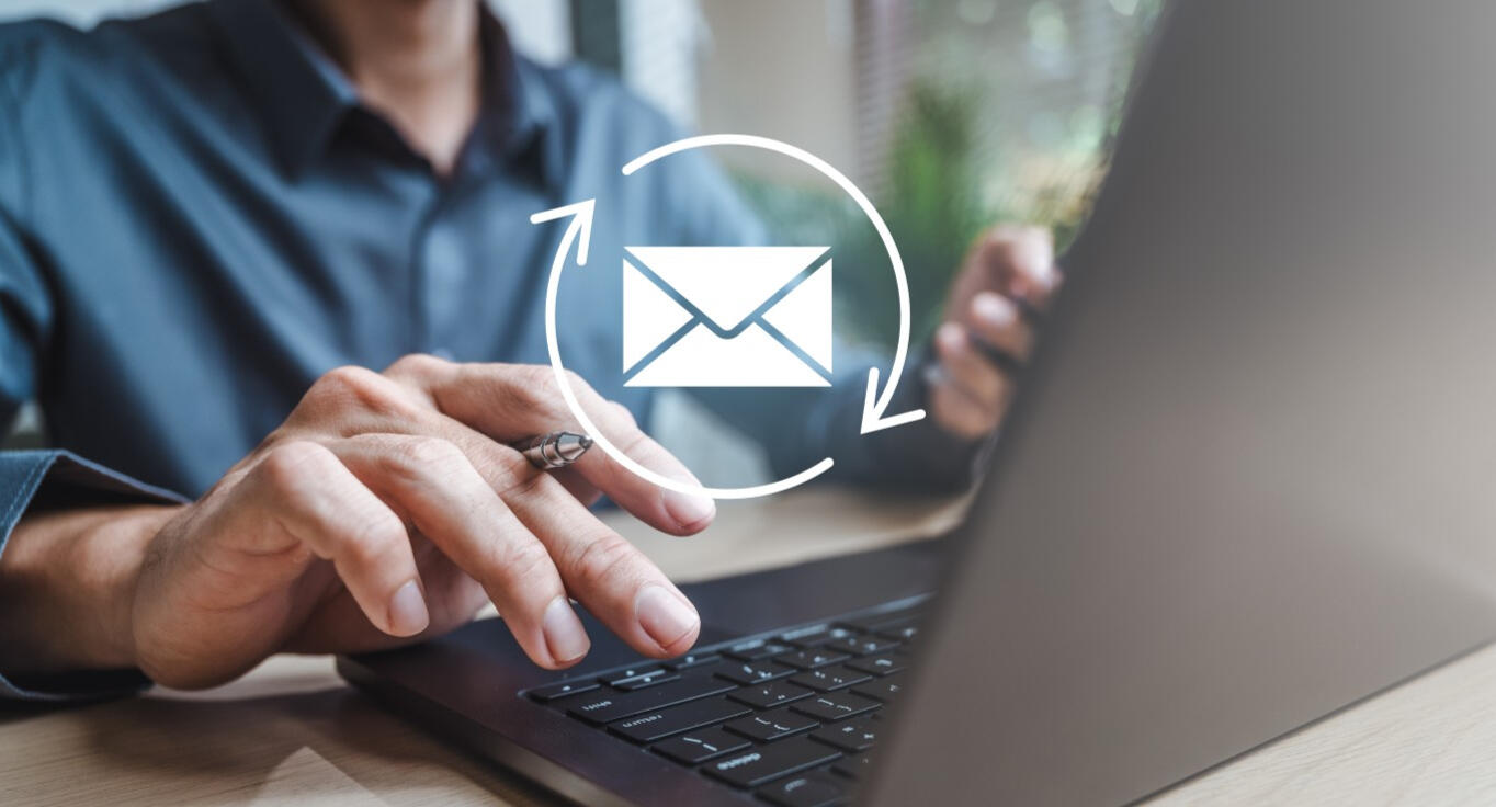 Person sending an email at a laptop.
